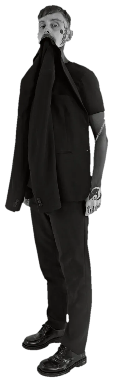 Simon in a black suit, holding his jacket up in his teeth