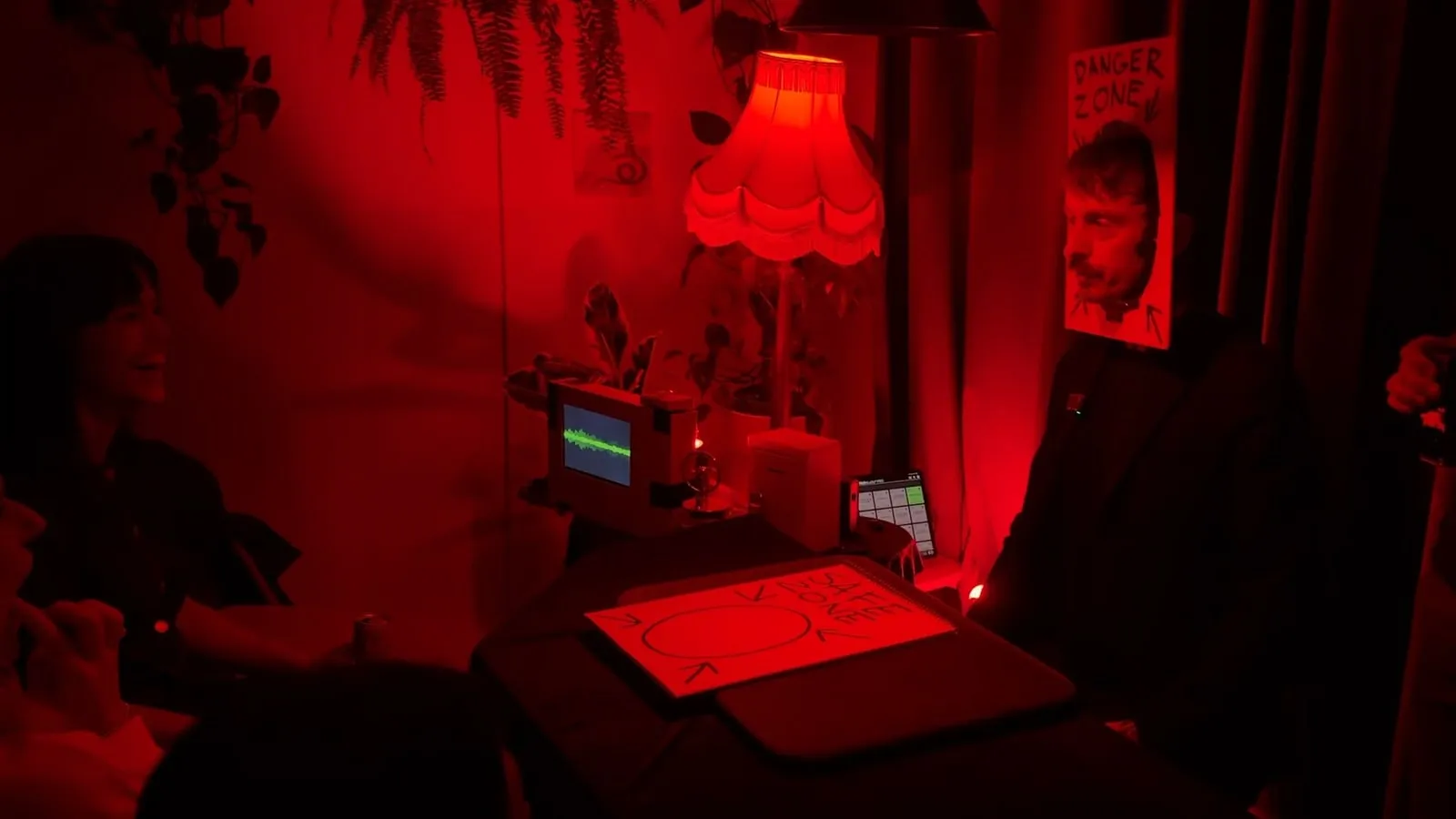 The theatre drenched in red light, the little monitor glowing on the table
